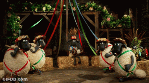 Sheep Wearing Hats And Ribbons In Barn GIF