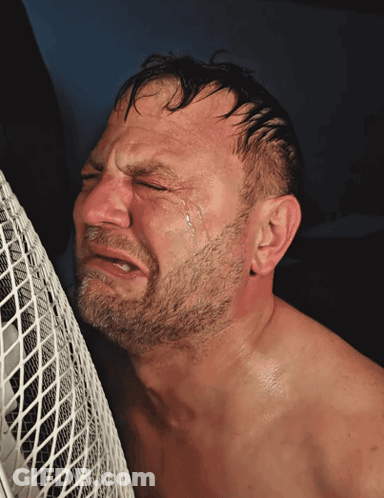 Shirtless Bearded Man Crying In Front Of White Fan GIF