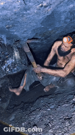 Shirtless Bearded Man Using Pickaxe In Cave GIF