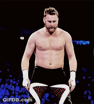 Shirtless Bearded Wrestler In Dark Room Facing Crowd GIF