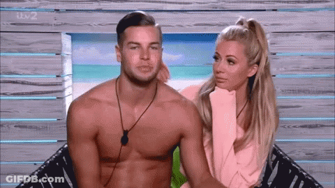 Shirtless Man And Woman Sitting On Beach GIF