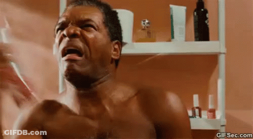 Shirtless Man Brushing Teeth By Perfume Shelf GIF