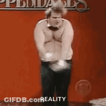 Shirtless Man Dancing On Stage With Reality Sign GIF