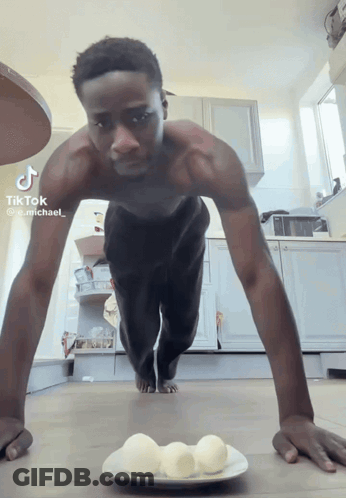 Shirtless Man Doing Push Ups Beside Plate Of Eggs GIF