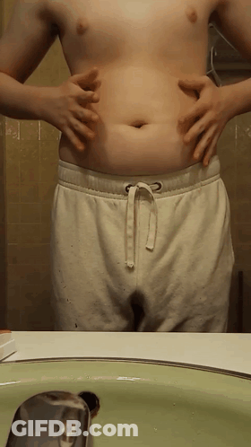 Shirtless Man Holding Belly At Bathroom Sink GIF