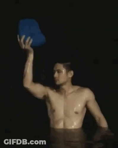 Shirtless Man Holding Blue Bucket Over Head In Water GIF