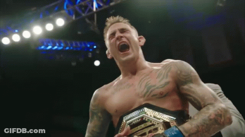 Shirtless Man Holding Championship Belt Screaming GIF