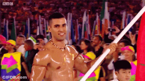 Shirtless Man Holding Flag At Parade GIF