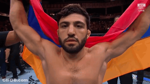 Shirtless Man Holding Multicolored Flag GIF
