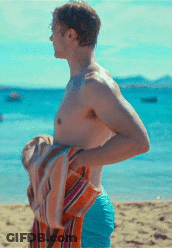Shirtless Man Holding Towel Over Shoulder On Beach GIF