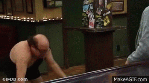Shirtless Man Holding Trash Can In Restaurant GIF