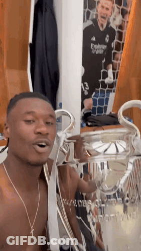 Shirtless Man Holding Trophy In Locker Room GIF