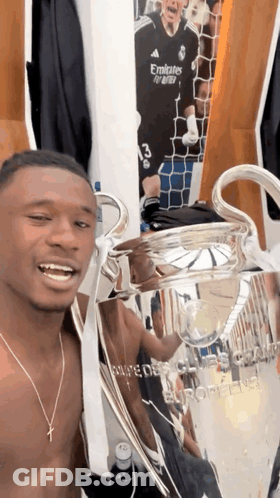 Shirtless Man Holding Trophy Saying Emirates GIF