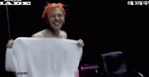 Shirtless Man Holding White Towel Next To Jade Chair GIF