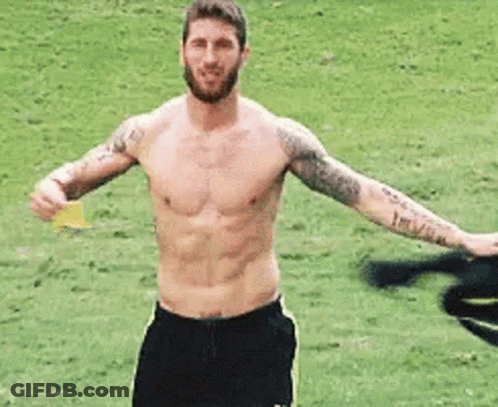 Shirtless Man Holding Yellow Card On Soccer Field GIF