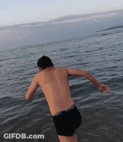 Shirtless Man In Black Shorts Jumping Into Water GIF