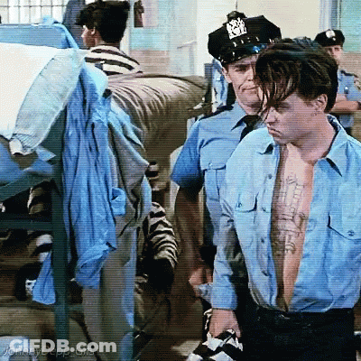 Shirtless Man In Blue Escorted By Police GIF