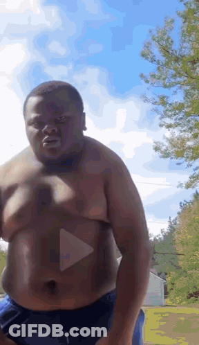 Shirtless Man In Blue Shorts Standing In Front Of Trees GIF
