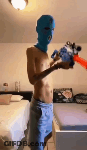Shirtless Man In Blue Ski Mask Holding Water Gun GIF