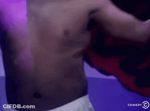 Shirtless Man In Front Of Comedy Sign GIF