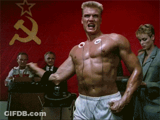 Shirtless Man In Front Of Red Wall With Hammer And Sickle GIF