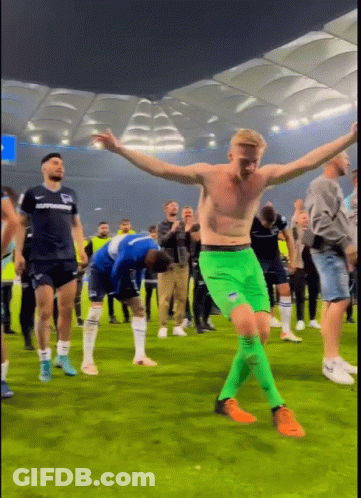 Shirtless Man In Green Shorts Dancing On Field GIF