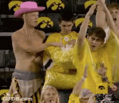 Shirtless Man In Pink Cowboy Hat In Front Of Yellow Shirt Crowd GIF