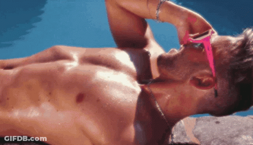 Shirtless Man In Pink Sunglasses Lying On Beach GIF