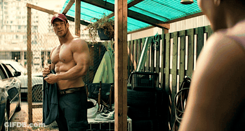 Shirtless Man In Red Hat Standing In Front Of Woman GIF