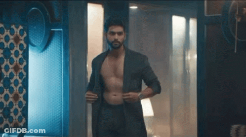 Shirtless Man In Suit And Underwear Standing In Dark Room GIF