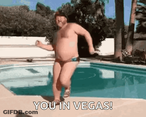 Shirtless Man In Swim Trunks Running By Pool GIF