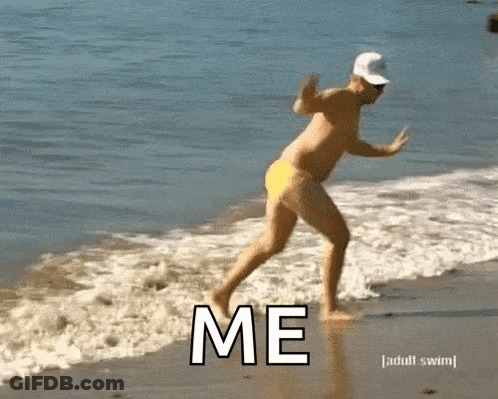 Shirtless Man In Yellow Swim Trunks Running Into Ocean Saying Me GIF