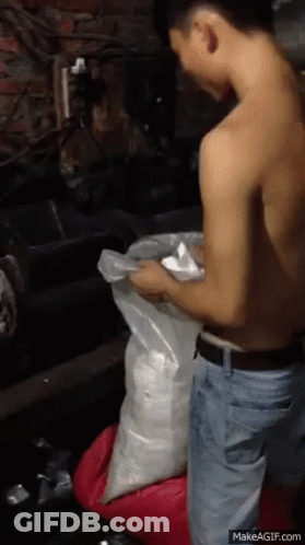 Shirtless Man Kneeling Holding Bag GIF