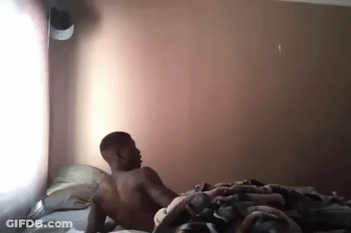 Shirtless Man Laying On Bed In Bedroom GIF