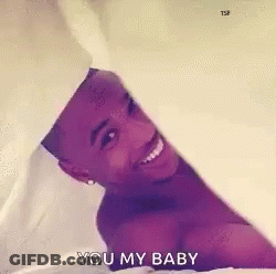 Shirtless Man Laying On Bed Smiling Holding White Sheet GIF