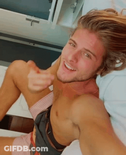 Shirtless Man Laying On Bed Smiling GIF