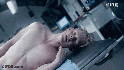 Shirtless Man Laying On Stretcher With Netflix Logo GIF