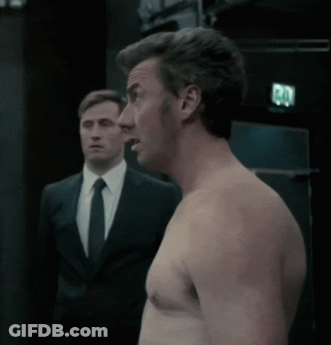 Shirtless Man Next To Man In Suit And Tie GIF