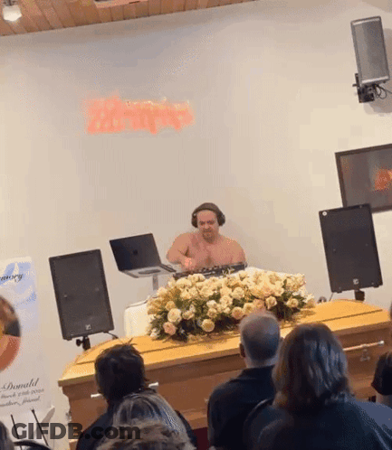 Shirtless Man Playing Music In Front Of Donald Sign GIF
