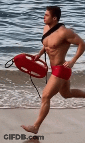 Shirtless Man Red Shorts Running With Life Preserver GIF