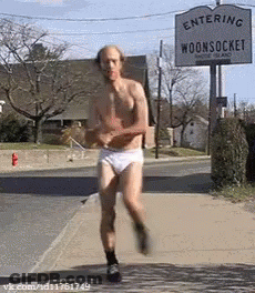 Shirtless Man Running Past Entering Woonsock Sign GIF