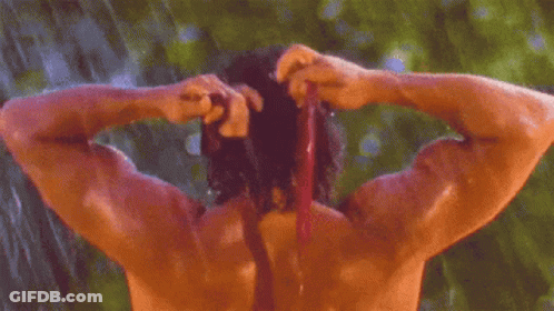 Shirtless Man Showering In Rain And Tying Hair GIF