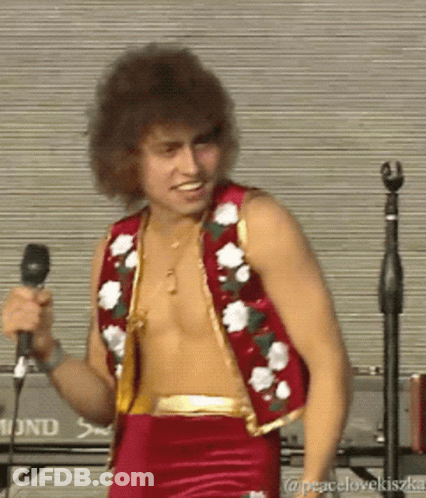 Shirtless Man Singing In Red Vest With Flowers GIF