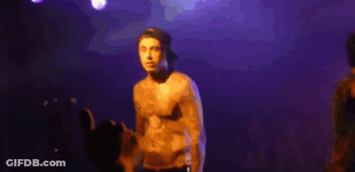 Shirtless Man Singing Into Microphone Purple Background GIF