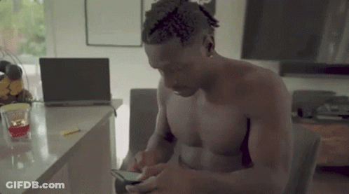 Shirtless Man Sitting At Laptop On Phone GIF