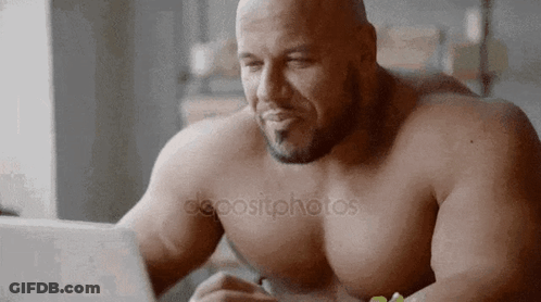 Shirtless Man Sitting At Table Using Laptop GIF