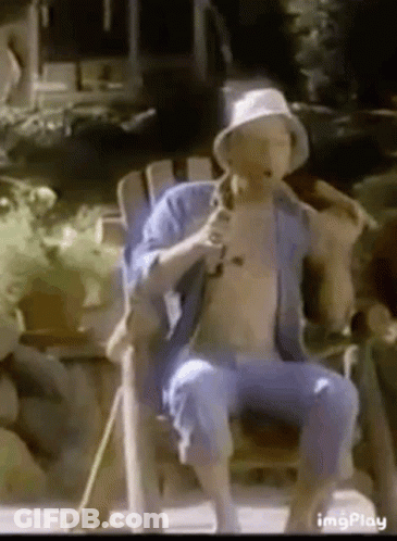 Shirtless Man Sitting In Chair With Cane And Microphone GIF