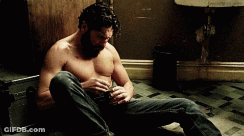 Shirtless Man Sitting In Front Of Sink GIF