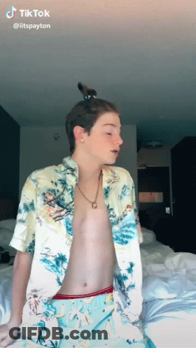 Shirtless Man Sitting On Bed With Cat In Hair GIF