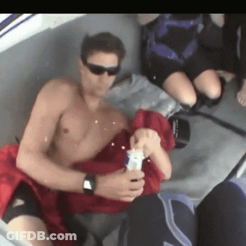 Shirtless Man Sitting On Boat Holding Bottle GIF